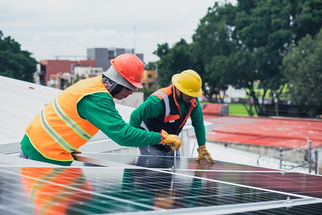 two workers installing a solar panel