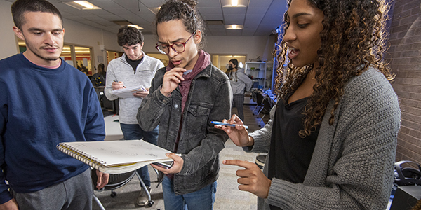 UCNJ students looking at notepad