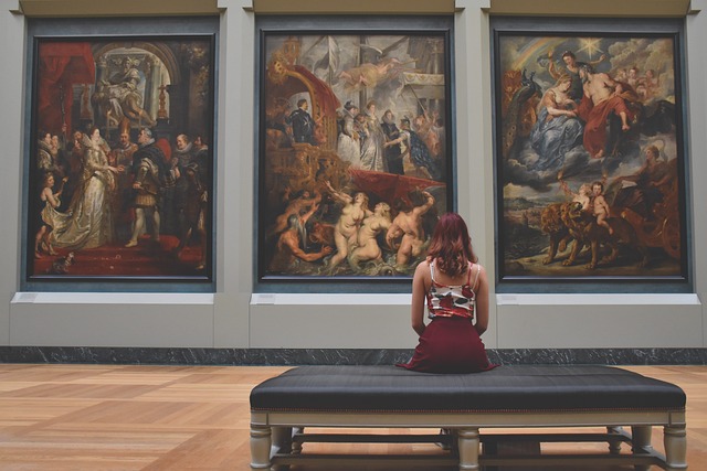 woman sitting in front of art work